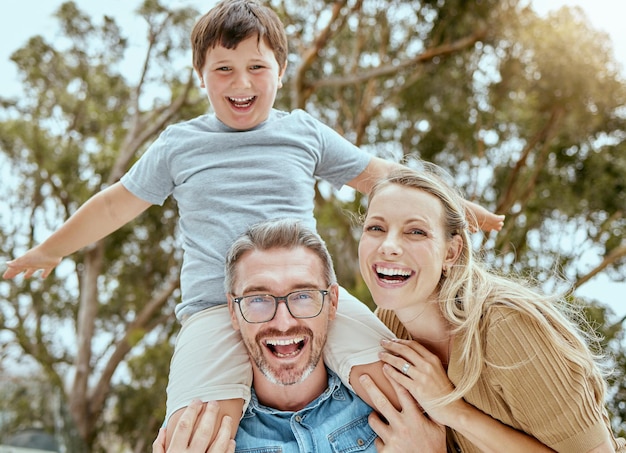 Portrait parents and child on shoulder outdoor for playful game family bonding and support of love in backyard Smile woman and man with boy for trust security and care for hug together in nature