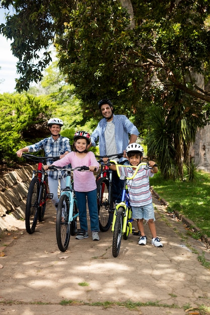부모와 어린이 공원에서 자전거와 함께 서의 초상화