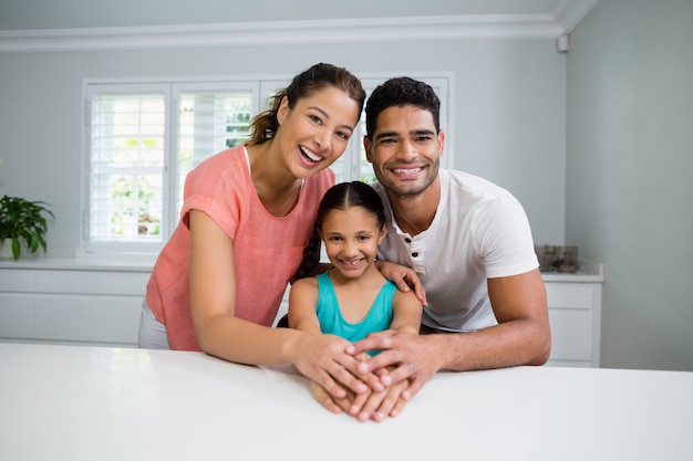 Portrait of parents and daughter standing together in kitchen