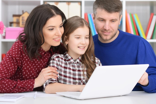 Photo portrait of parents and daughter using laptop