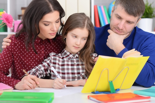 Portrait of parents helping daughter with lessons