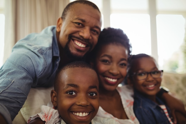 Portrait of parents and son sitting on sofa in living room