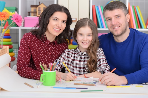 Portrait of parents with daughter draw together