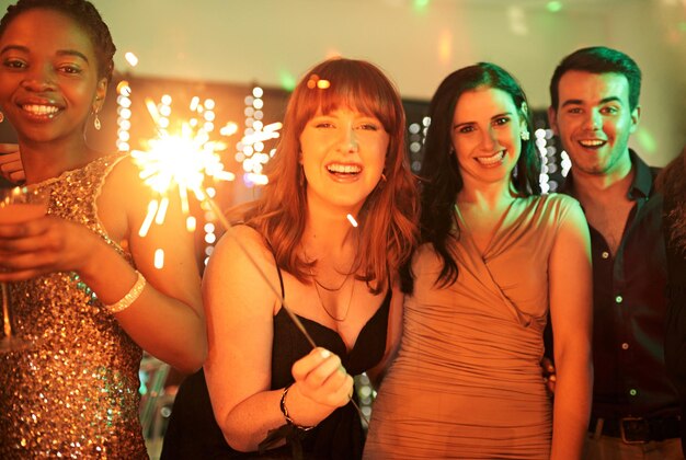portrait party and friends with sparklers celebration and excited with happiness new year and achievement fireworks group or event with joy birthday or social gathering with people and smile