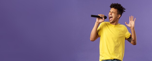 Photo portrait of passionate carefree young hispanic singer with dreads and tattoos reaching highest note