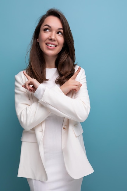 portrait of pensive brunette woman in white dress looking up