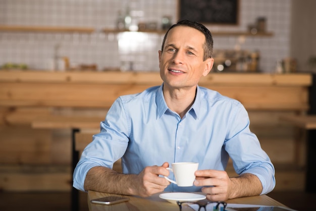 Photo portrait of pensive businessman drinking coffee at cafe