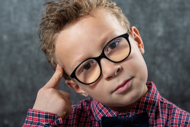 Ritratto di bambino carino pensoso con camicia a scacchi