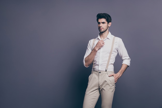 Portrait of pensive dreamy  guy ideal man look good copy space adjust fix his button on classic shirt .