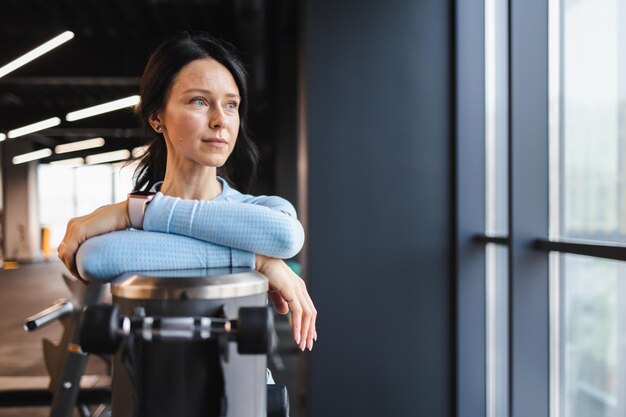 ジムで物思いにふけるフィットネス女性の肖像画