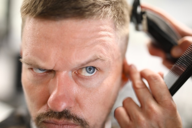 Portrait of pensive man who is being cut with a machine