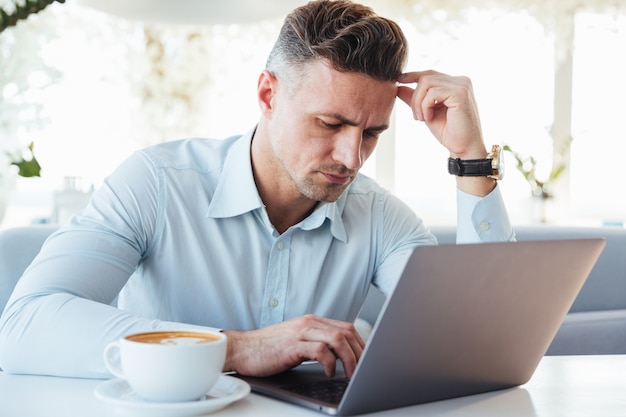 Portrait of a pensive mature man using laptop