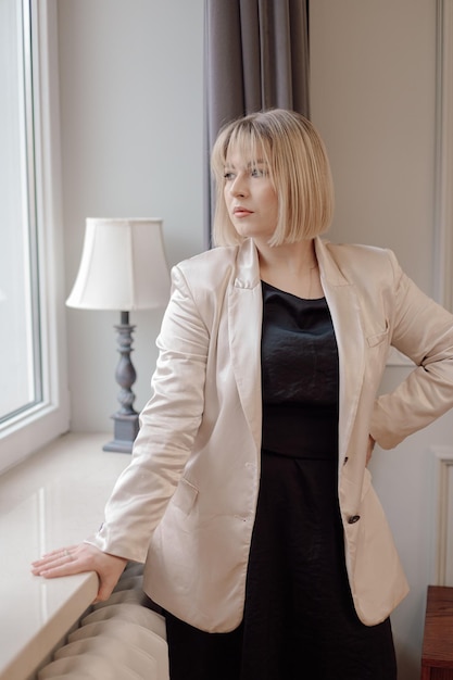 Portrait of pensive perfect middleaged woman businesswoman with short hair standing near lamp lookin