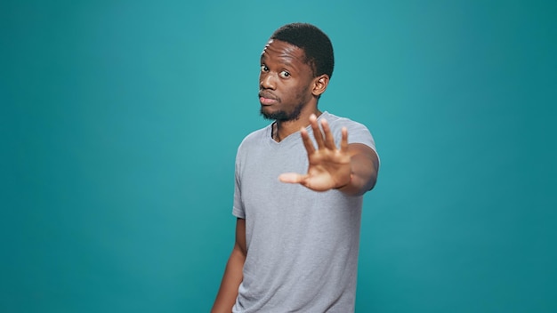 Portrait of person doing talk to the hand rejection gesture,\
expressing refusal and disapproval. negative man advertising no\
sign and disagreeing, showing dislike symbol in studio.