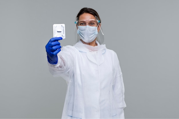 Photo portrait of person wearing medical gown and holding pills