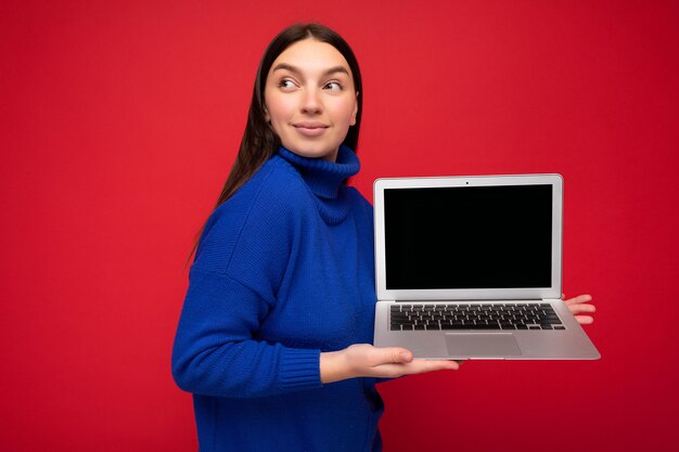 Photo portrait photo of beautiful young brunet lady holding computer laptop looking to the side