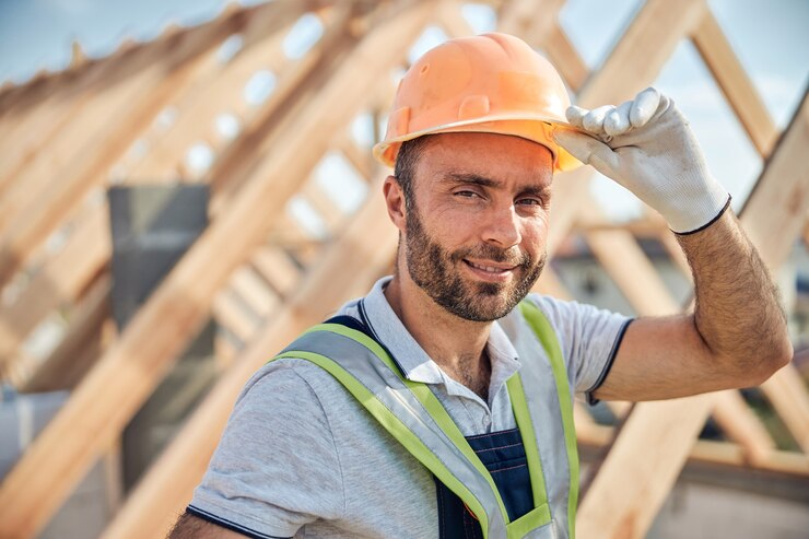 Photo portrait photo of an experienced builder touching his hard hat and looking at the camera