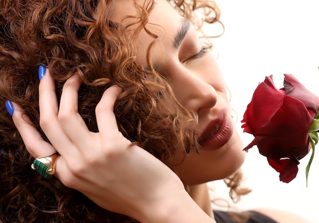 Portrait photo of romantic girl with curly hair with red rose