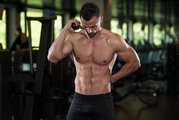 Portrait Of A Physically Fit Man Posing With Triceps Rope In Modern Fitness Center Gym