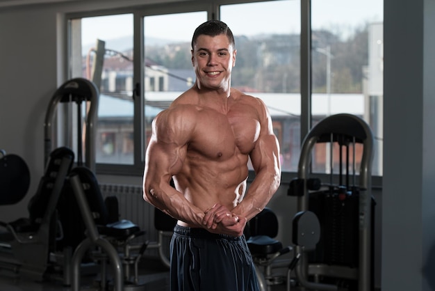 Portrait Of A Physically Fit Man Showing His Well Trained Body In Gym