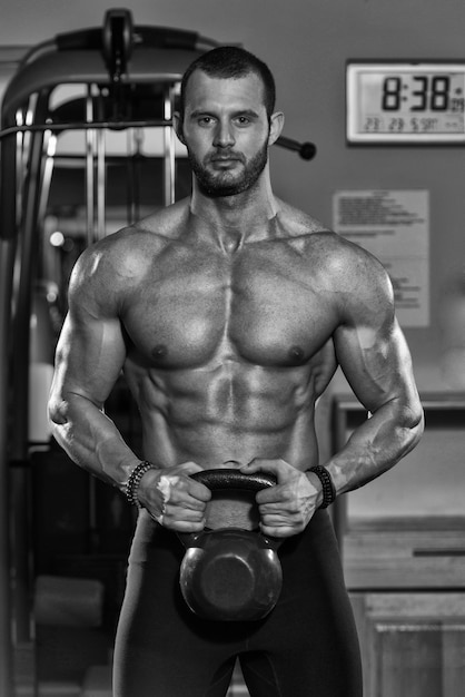 Portrait Of A Physically Young Man Holding Weights In Hand