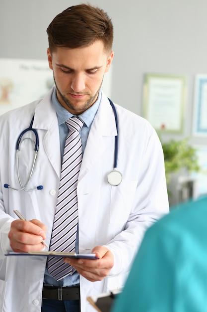 Portrait of physician looking down at notepad