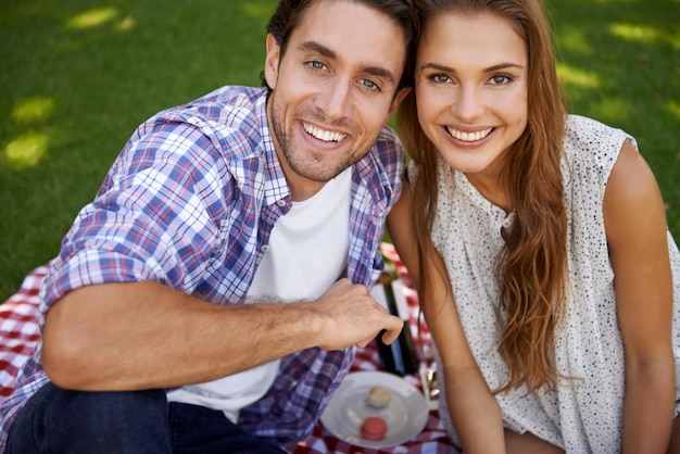 Portrait picnic and date with a couple in a park together during summer for love romance or bonding Face nature or dating with a young man and woman in a garden for a romantic celebration