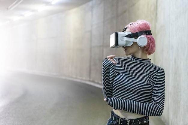 Portrait of pink haired girl wears VR glasses and looking aside