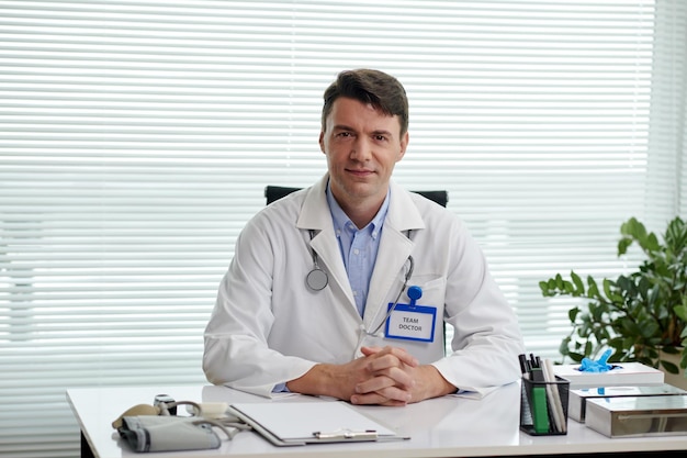 Portrait of plastic surgeon working with documents at office table