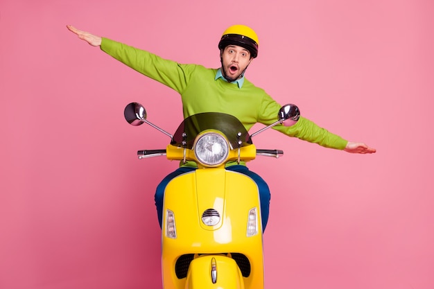 Portrait of playful childish guy riding moped  plane flying having fun