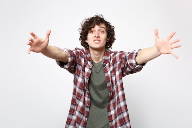 Portrait of pleading amazed young man in casual clothes stand with spreading outstretching hands isolated on white background in studio. People sincere emotions lifestyle concept. Mock up copy space.