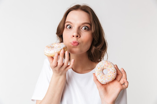 Portrait of a pleased young woman eating a donut