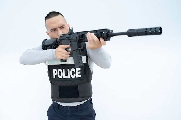 Portrait of police hold gun in hand on white backgroundHandsome asian cop