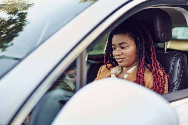 Portrait of positive african american lady inside the car