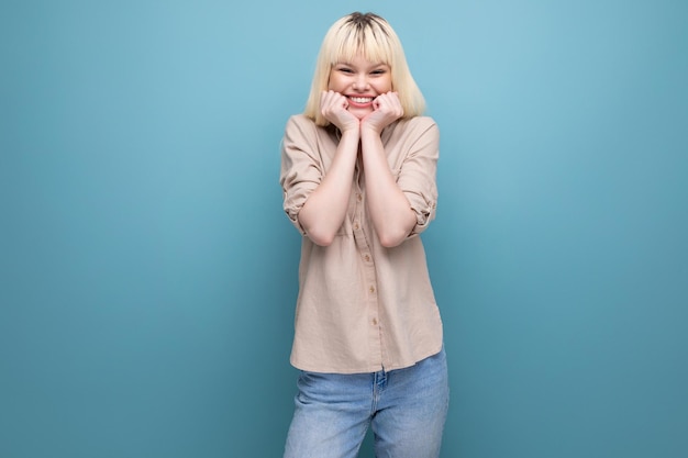 Portrait of a positive blond european young woman in a shirt with emotions of happiness