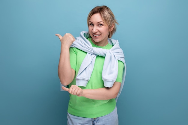 portrait of a positive bright young woman in a casual outfit on a blue background with copy space