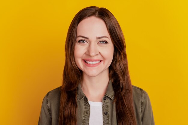 Portrait of positive cheerful charming girl toothy smile on yellow background