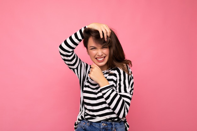 Portrait of positive cheerful fashionable woman in casual clothes isolated on pink background with