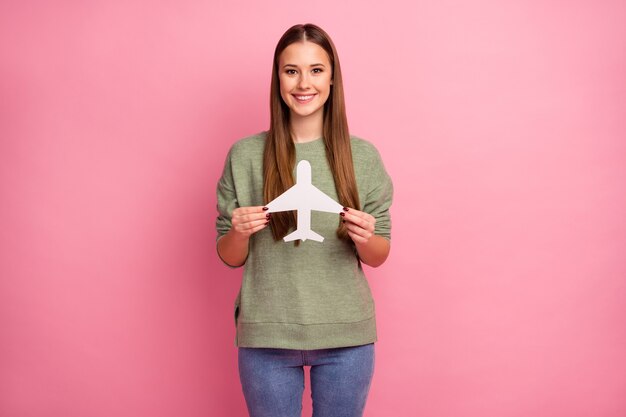 ポジティブな陽気な女の子の肖像画は、白い紙のカード飛行機を保持します