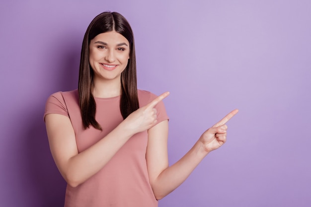 Portrait of positive cheerful girl point index finger copyspace advert advice choice suggest promo isolated over violet color background