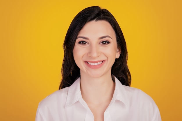 Портрет позитивной жизнерадостной девушки с зубастой сияющей улыбкой на желтом фоне