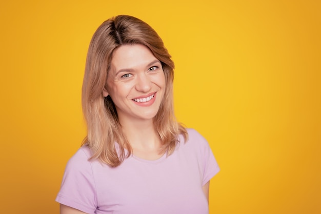 Portrait of positive cheerful lady posing look camera enjoy free time on yellow background