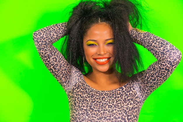 Portrait of a positive cheerful woman in bright makeup posing isolated on green