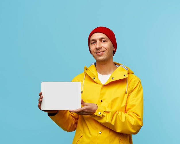 Portrait of positive cool man showing blank white screen of tablet