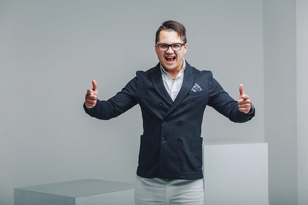 Portrait of positive emotional guy in hipster glasses and stylish haircut