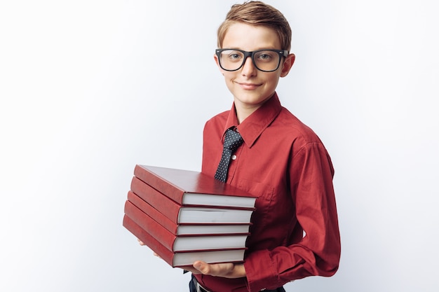 Portrait of positive and emotional schoolboy holding books