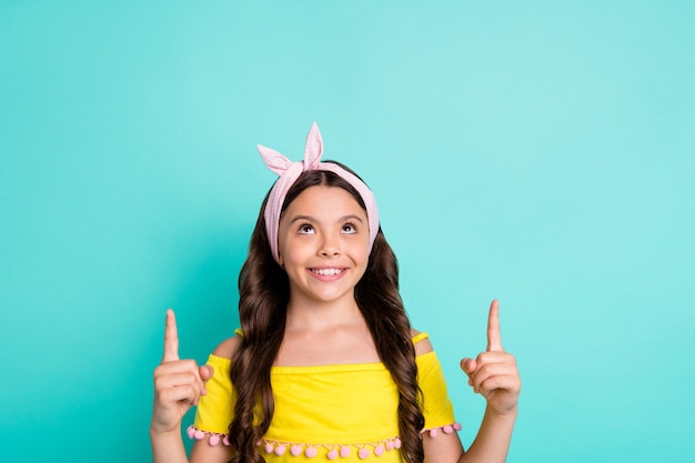 Portrait of positive girl kid point index finger indicate ads promotion