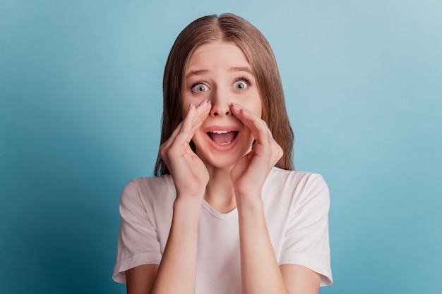 Photo portrait of positive girlish announcer teen lady hands mouth talk on blue background