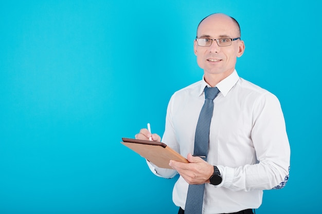 Portrait of positive manager in glasses using digital pen when writing on tablet computer