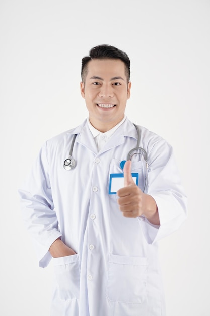 Portrait of positive mature doctor showing thumbsup isolated on white